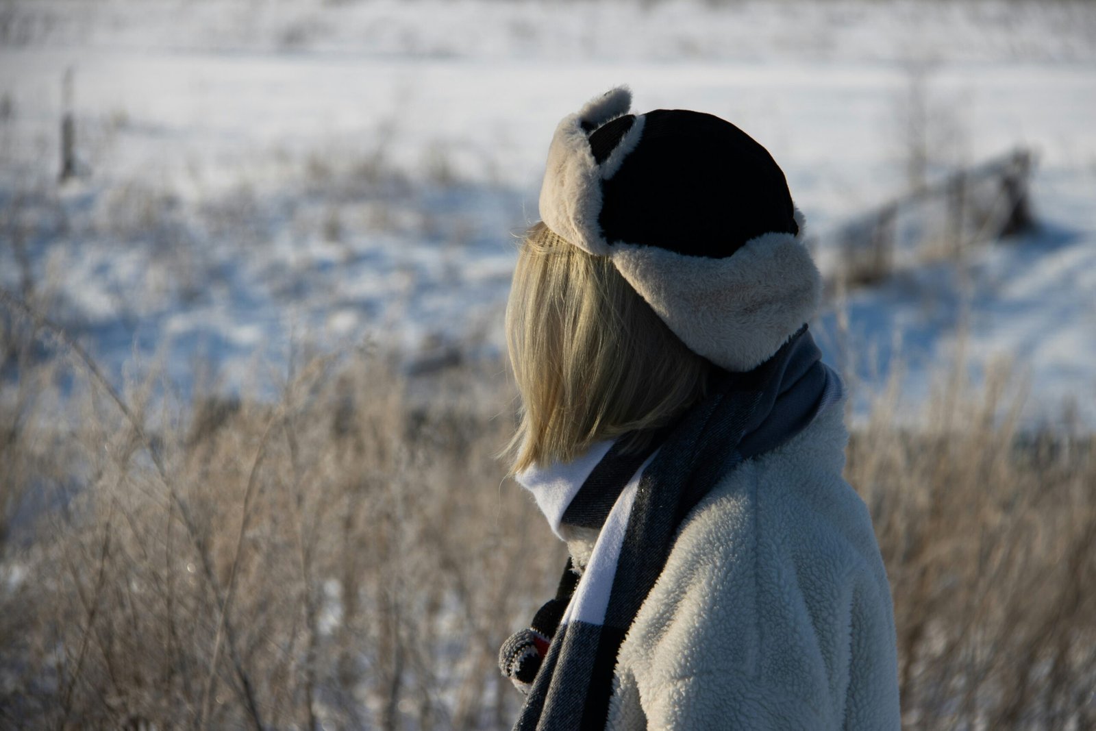 a woman wearing a hat and scarf in the snow